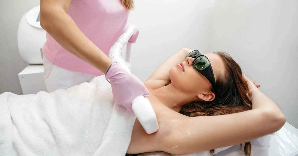 Woman receiving underarm laser hair removal treatment while wearing protective eyewear at Divine Age Med Spa in Wesley Chapel, FL.