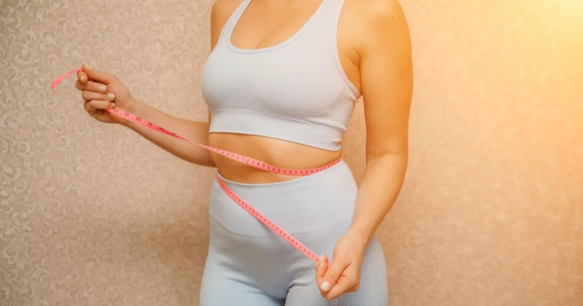 Woman measuring her waist while showcasing semaglutide weight loss results at Divine Age Med Spa in Wesley Chapel, FL.
